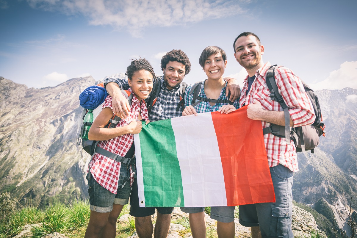 Gente con la bandera italiana en la cima de una montaña
