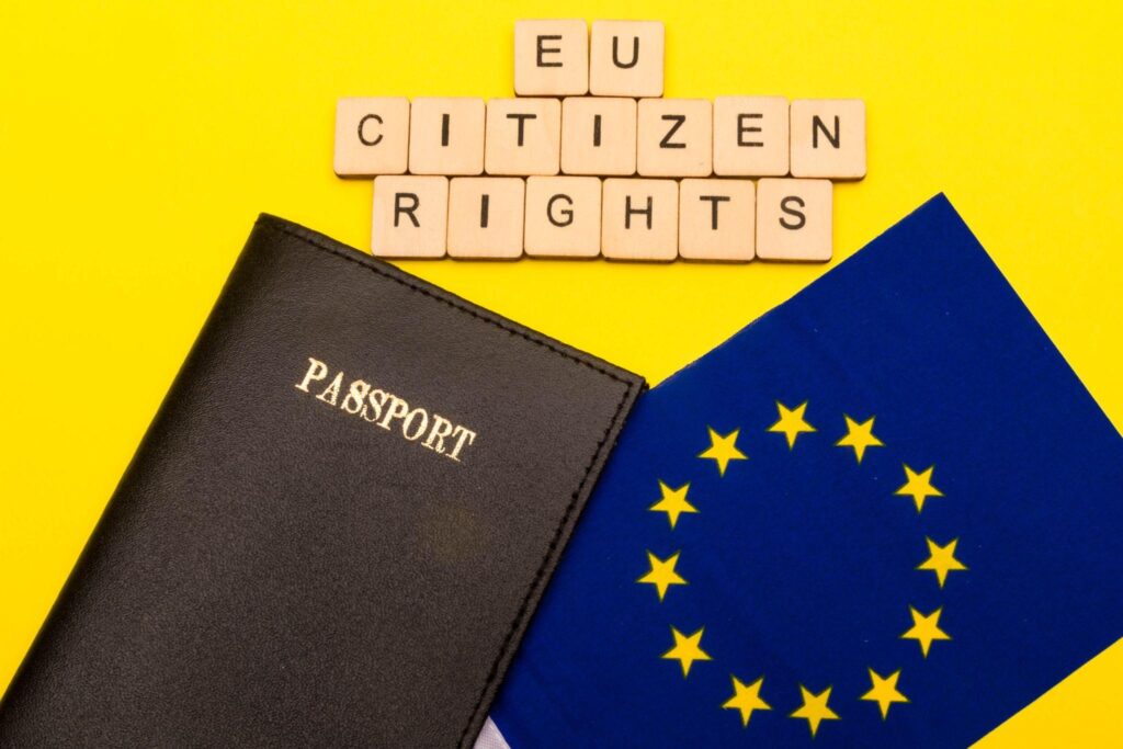 Concepto de la Unión Europea que muestra la bandera de la UE y un pasaporte sobre fondo amarillo con un cartel en el que se lee Derechos de los ciudadanos de la UE