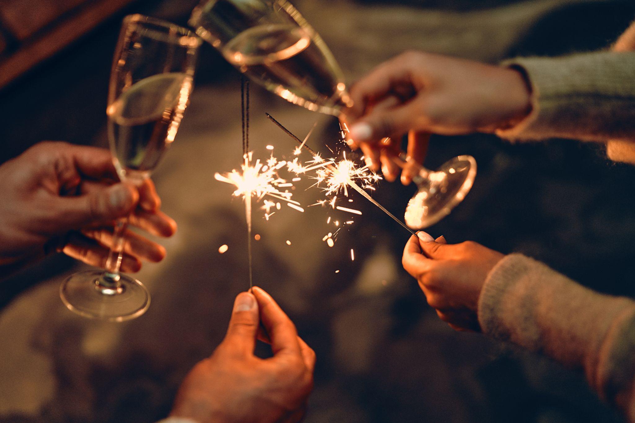 Man holding sparkles and champagne glass New Year party