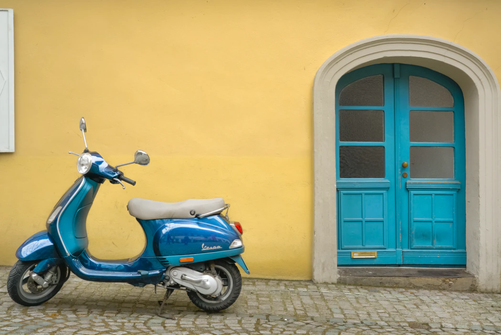 moto scooter azul à porta de casa