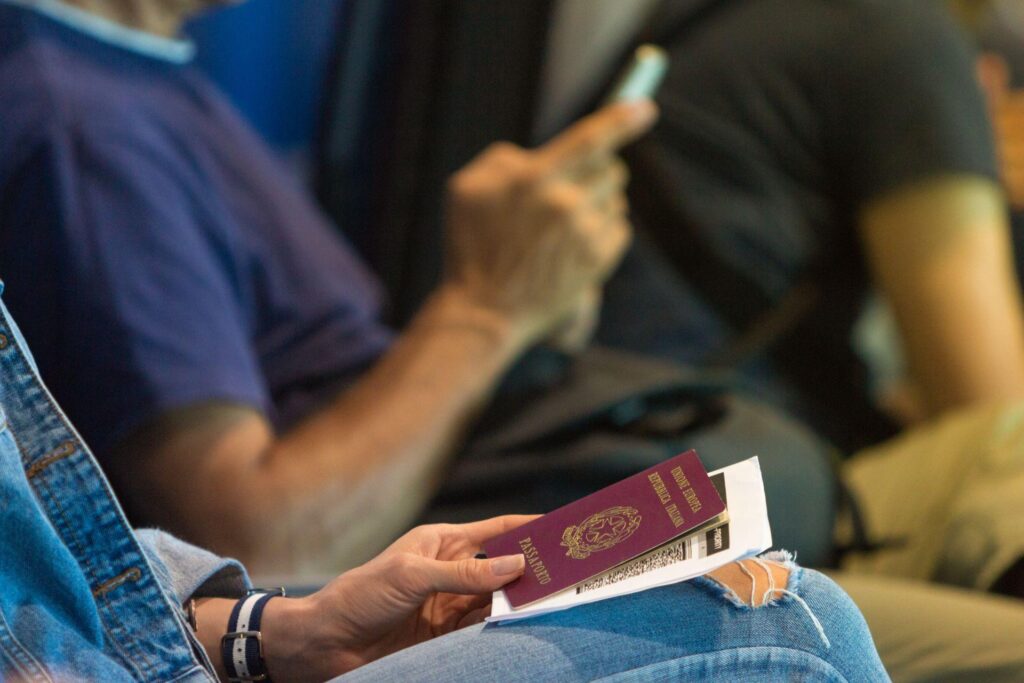 Mujer está esperando su vuelo en el vestíbulo del aeropuerto con el pasaporte y la tarjeta de embarque en la mano