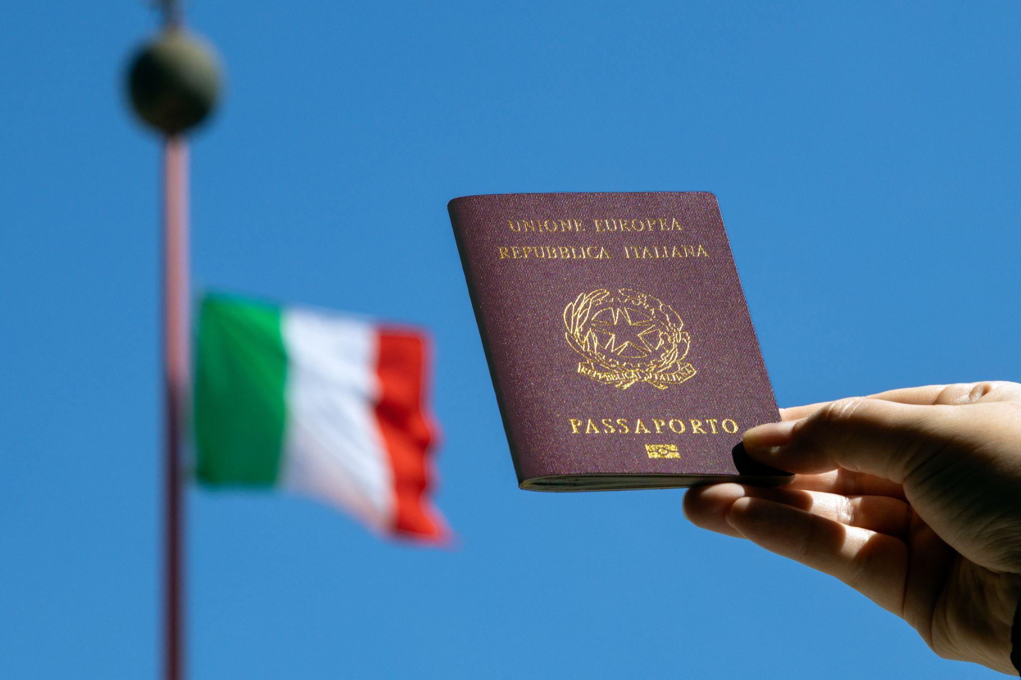 An Italian passport with an Italian flag in the background