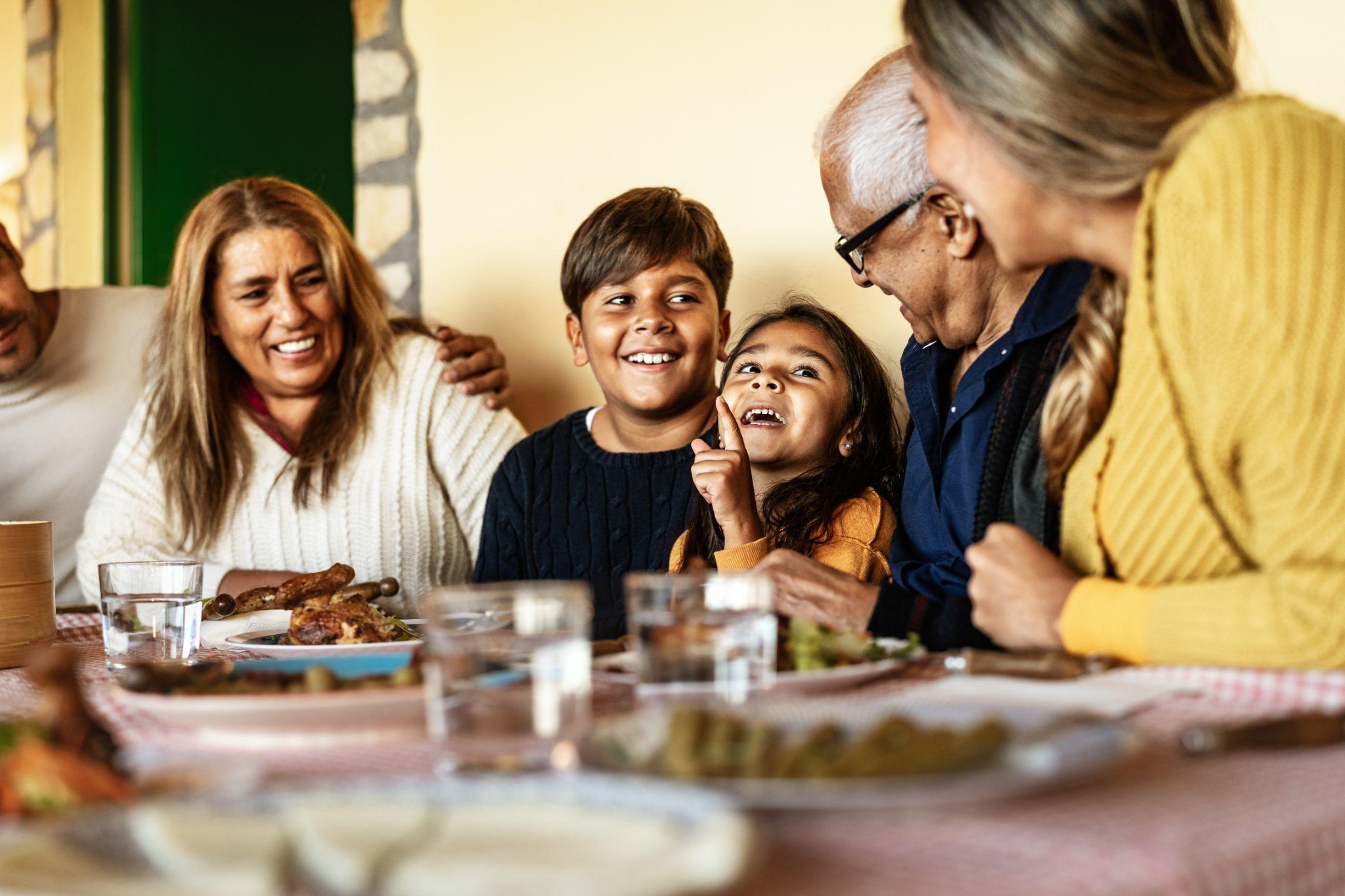 Una familia latina feliz se divierte comiendo junta en casa
