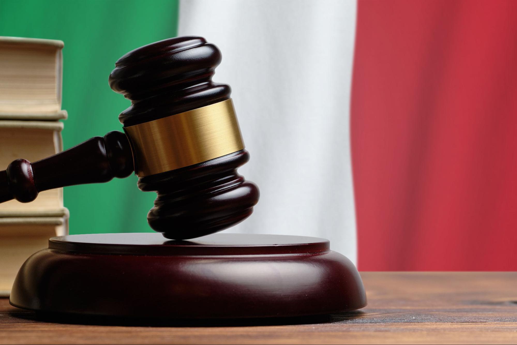 Un mazo judicial sobre un fondo con la bandera italiana