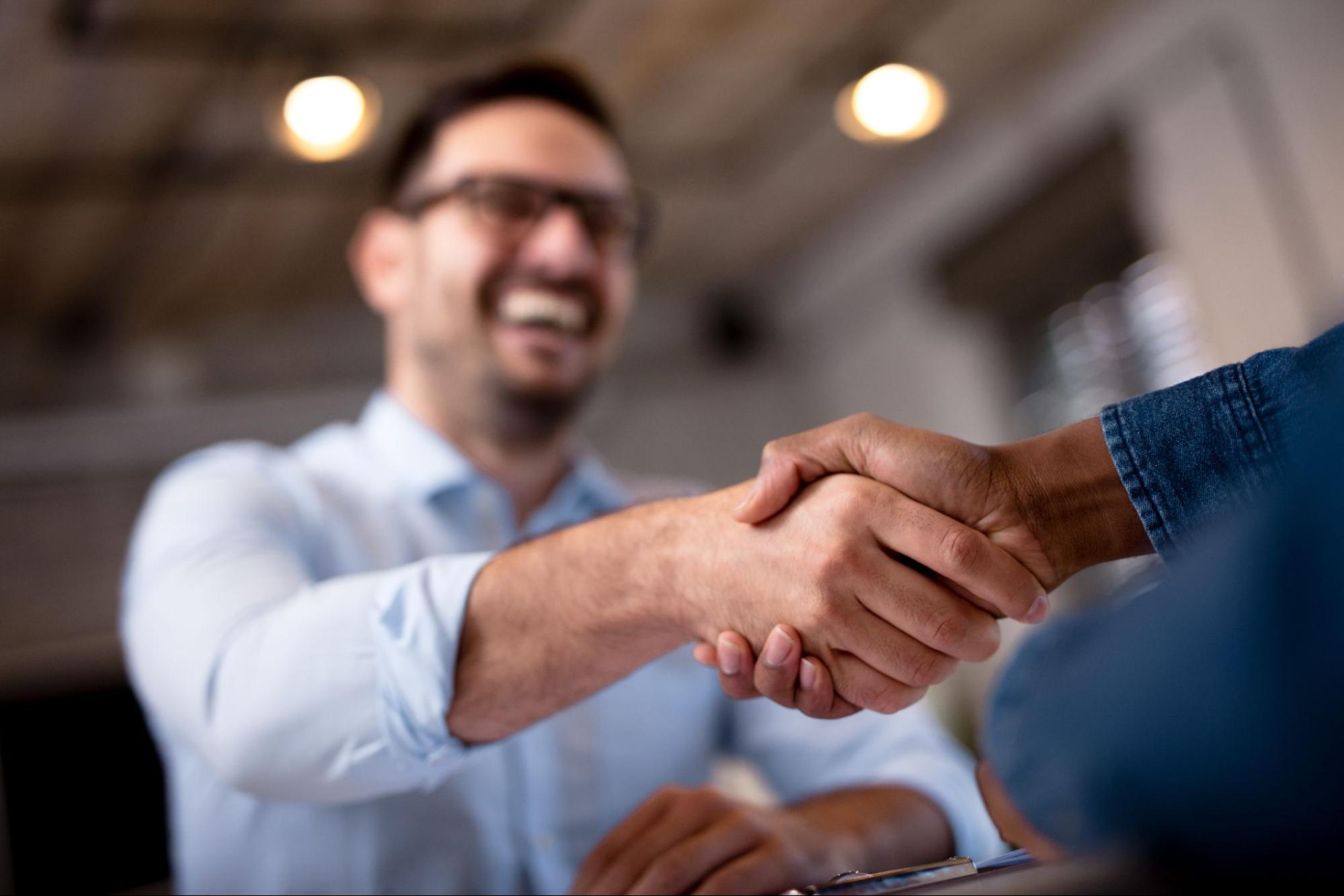 A man being hired and shaking hands